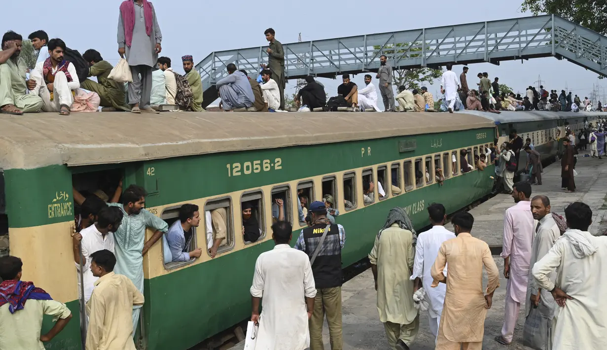Warga Pakistan menaiki kereta api yang penuh sesak saat orang-orang melakukan perjalanan ke kampung halaman dan desa mereka untuk merayakan Idul Adha, atau "Hari Raya Kurban," di Lahore, Pakistan, Kamis (7/7/2022). Idul Adha, hari raya Islam terpenting, menandai kesediaan Nabi Ibrahim, Ibrahim untuk mengorbankan anaknya. (AFP/Arif Ali)