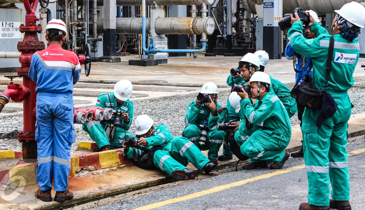 Sejumlah jurnalis foto dengan berbagai gaya mengabadikan kawasan kilang pengolahan minyak Pertamina (RU V) di Balikpapan, Kalimantan, Kamis (14/05). (Liputan6.com/Fery Pradolo)