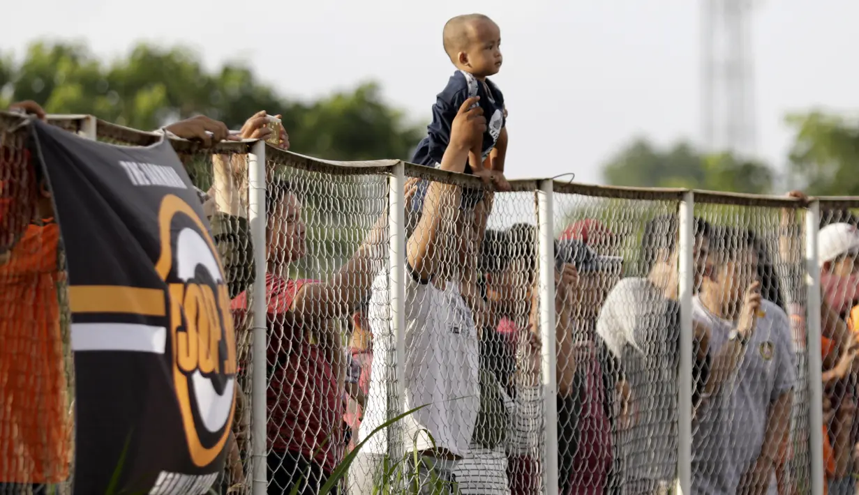 Seorang anak digendong bapaknya untuk melihat pemain Persija Jakarta latihan di Lapangan NYTC, Sawangan, Depok, Selasa (21/1/2020). Warga antusias melihat punggawa Macan Kemayoran berlatih. (Bola.com/M Iqbal Ichsan)