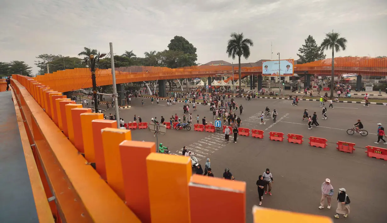 Warga beraktivitas di sekitar Jembatan Penyeberangan Orang (JPO) di Jalan Tegar Beriman, Cibinong, Kabupaten Bogor, Jawa Barat, Minggu (14/6/2026). (Kapanlagi.com/Budy Santoso)