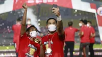 Kiper merangkap kapten Persija Jakarta, Andritany Ardhiyasa (kanan) bersama Ramdani Lestaluhu melakukan selebrasi usai menjuarai Piala Menpora 2021 di Stadion Manahan, Solo, Minggu (25/4/2021). (Bola.com/M Iqbal Ichsan)