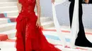 Salma Hayek tampil seperti emoji dengan gaun merah Gucci-nya yang berani. Begitu juga riasan dari Sofia Tilbury dengan bibir merah yang bold. [@themetgalaofficial]