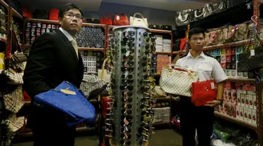 Petugas memperlihatkan sejumlah barang palsu di Kantor Bea Cukai Hong Kong, Kamis (6/8). Lebih dari 30.000 barang disita dari satu warga Filipina dan dua warga Pakistan yang merupakan sindikat penjual barang yang diduga palsu. (REUTERS/Bobby Yip)