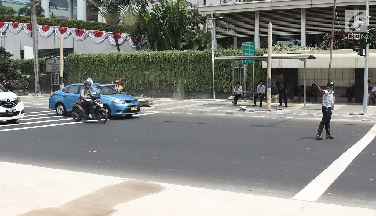 Petugas mengatur lalu lintas di pelican crossing di kawasan Thamrin, Jakarta, Minggu (29/7). Pelican crossing di kawasan Thamrin sudah bisa di gunakan pengganti JPO yang akan dibongkar. (Liputan6.com/Herman Zakharia)