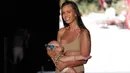 Model Mara Martin berjalan di atas runway sambil menyusui bayinya mengenakan pakaian renang Sports Illustrated pada Miami Swim Week 2018 di Florida, Minggu (15/8). Mara tersenyum saat berjalan dan mendapat tepuk tangan dari penonton. (AP/Lynne Sladky)