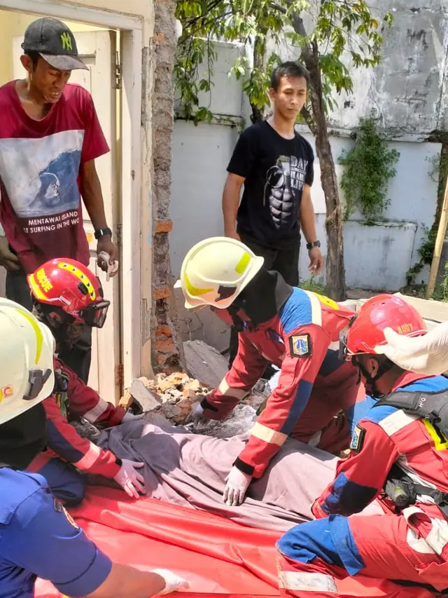 Petugas Gulkarmat Jakarta Timur saat mengevakuasi korban bangunan roboh di Kramat Jati, Jakarta Timur.