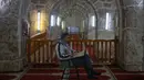 Setiap Ramadan tiba, Kubah Batu di kompleks Masjid al-Aqsa ramai dikunjungi umat Muslim untuk menghabiskan waktu dengan membaca Al-Quran. Tampak dalam foto, seorang pria Palestina membaca Al-Quran di dalam masjid al-Marawani yang terletak di kompleks Masjid al-Aqsa, Yerusalem menjelang waktu berbuka puasa selama bulan suci Ramadan 1447 Hijriah pada Rabu 25 Februari 2026. (AHMAD GHARABLI/AFP)