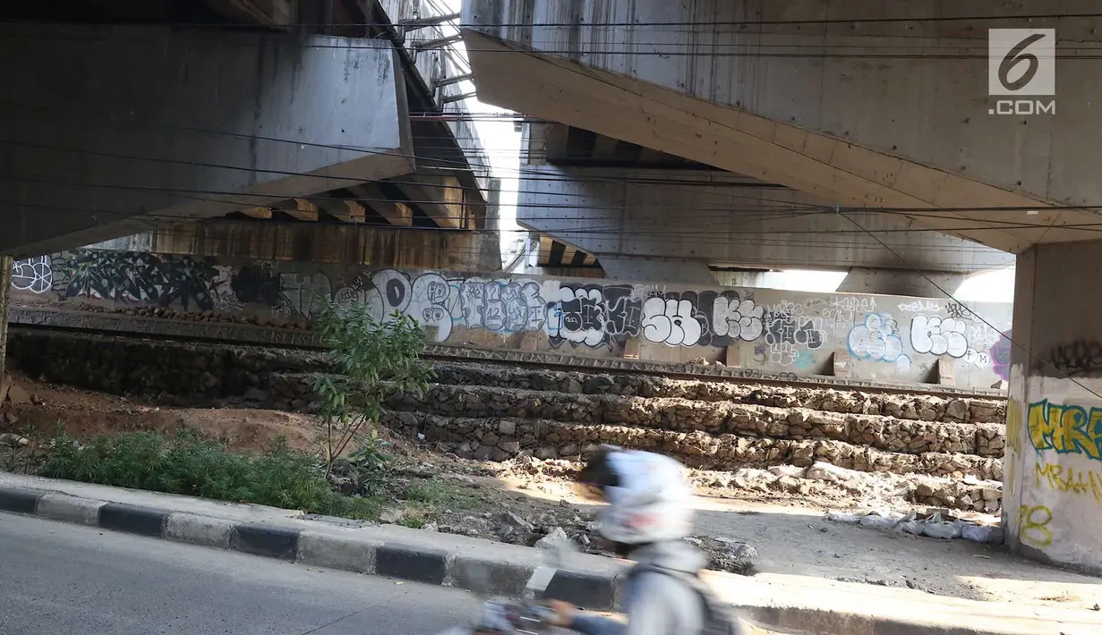 Pengendara sepeda motor melintasi kolong Flyover Kuningan, Jakarta, Selasa (25/9). Coretan terlihat memenuhi dinding kolong Flyover Kuningan. (Liputan6.com/Immanuel Antonius)