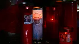 Lilin diletakkan di patung Yohanes Paulus II di luar Rumah Sakit Universitas Gemelli di mana Paus Fransiskus dirawat di rumah sakit karena pneumonia, di Roma pada tanggal 3 Maret 2025. (Filippo MONTEFORTE/AFP)