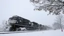 Sebuah kereta barang melaju saat badai salju di Manville, New Jersey (21/3). Badai salju yang melanda sebagian Amerika Serikat telah membawa salju dan angin kencang. (AP/Julio Cortez)