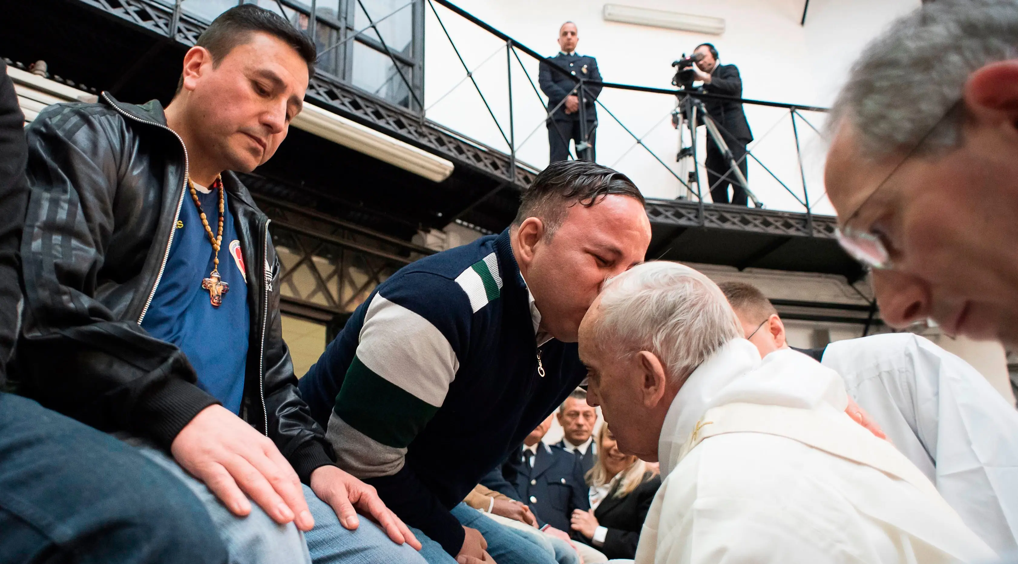Paus Fransiskus mendapat ciuman seorang narapidana usai mencuci dan mencium kakinya selama berkunjung ke pusat penahanan di Roma, Italia, Kamis (29/3). Kunjungannya ini untuk merayakan 