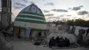 Meski berada di tengah puing-puing dan duka, momen berbuka puasa tetap dirayakan sebagai simbol kekuatan iman dan kebersamaan keluarga di Gaza. Tampak dalam foto, keluarga Suleiman berbuka puasa di bulan suci Ramadan di samping reruntuhan masjid, tempat mereka saat ini berlindung di Deir al-Balah, Jalur Gaza, Jumat 6 Maret 2026. (AP Photo/Abdel Kareem Hana)