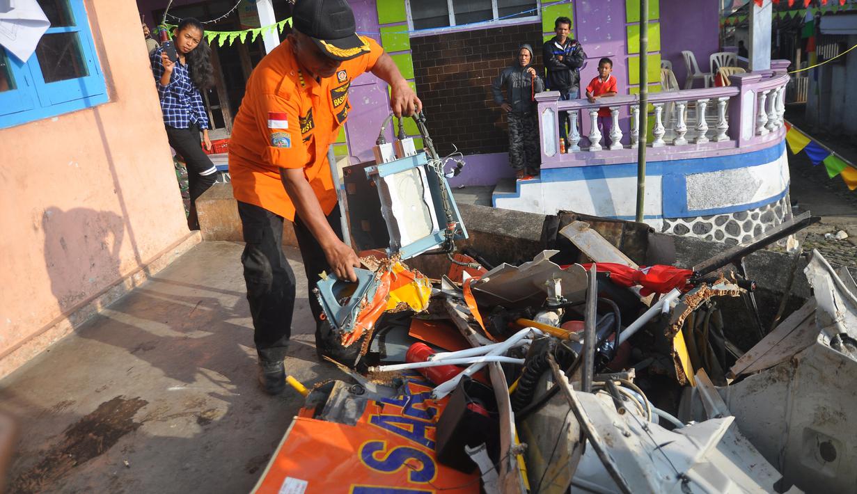 Petugas dari Basarnas memeriksa sisa bangkai helikopter Basarnas yang jatuh di Temanggung, Jawa Tengah (3/7). Kecelakaan tersebut menewaskan delapan orang yang terdiri dari 4 kru dan 4 rescue. (AFP Photo/STR)