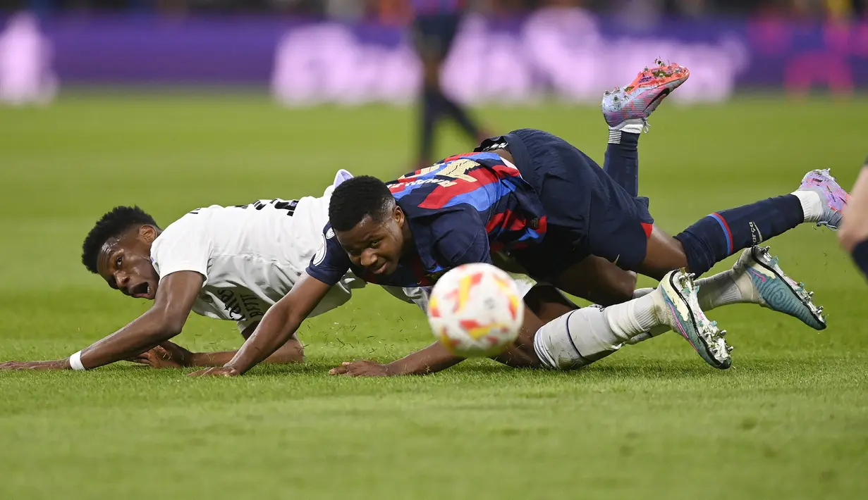 Pemain Real Madrid, Aurelien Tchouameni (kiri) berebut dengan pemain Barcelona, Ansu Fati pada laga leg pertama semifinal Copa Del Rey 2022/2023 di Santiago Bernabeu, Madrid, Jumat (03/03/2023) WIB. Laga berakhir dengan skor 1-0 untuk kemenangan Barcelona. (AFP/Oscar Del Pozo)