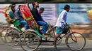 Foto yang diambil pada tanggal 13 Desember 2023 ini menunjukkan para pengemudi becak sepeda yang sedang mengangkut penumpang di Dhaka. (Munir UZ ZAMAN/AFP)