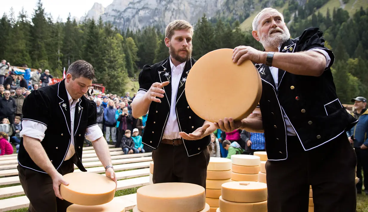 Para pembuat keju membagikan keju untuk petani di kawasan padang rumput pegunungan Justistal, Swiss (22/9). Pembuatan keju di Swiss telah menjadi tradisi di negara ini selama beratus-ratus tahun. (Peter Klaunzer / Keystone via AP)