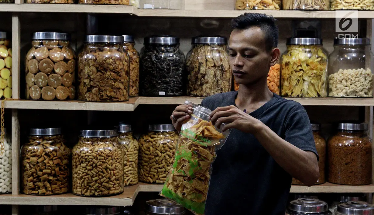 Pedagang memasukan kue kering di Pasar Mayestik, Jakarta Selatan, Senin (11/6). Separuh Ramadan dan jelang lebaran masyarakat mulai berburu kue kering. (Liputan6.com/Johan Tallo)