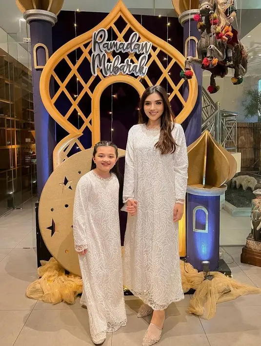 <p>Tampil simple dan elegan di Hari Raya dengan gamis kombinasi satin, dan brokat, serta payet seperti yang dikenakan Ashanty dan Arsy ini. (Instagram/ashanty_ash).</p>