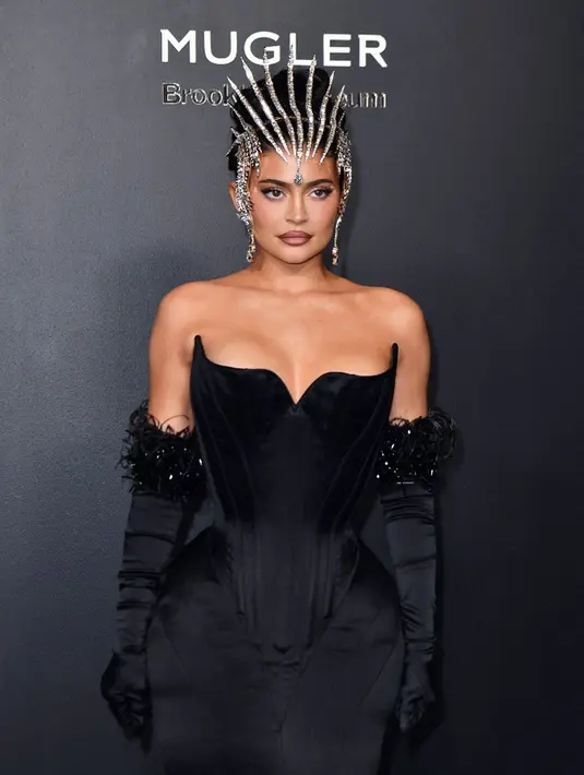<p>Kylie Jenner tiba pada pembukaan pameran Thierry Mugler: Couturissime di Brooklyn Museum, Brooklyn, New York City, Amerika Serikat, 15 November 2022. Gaun Kylie menampilkan potongan telinga kucing dan rok bergaya putri duyung yang menempel erat pada kakinya indahnya. (ANGELA WEISS/AFP)</p>