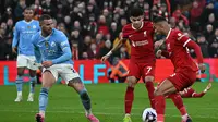 Gelandang dan striker Liverpool, Luis Diaz dan Cody Gakpo, ketika ditantang bek sayap Man City, Kyle Walker, dalam laga pekan ke-28 Premier League 2023/2024 di Anfield, Minggu (10/3/2024) malam WIB. (Paul ELLIS / AFP)