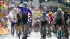 Jasper Philipsen melakukan selebrasi saat melewati garis finis di depan pebalap Jerman Phil Bauhaus yang menempati posisi kedua (kanan), untuk memenangkan etape ketiga balap sepeda Tour de France di Bayonne, Prancis, Senin (3/7/2023). (AP Photo/Daniel Cole)