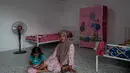 Penyerahan huntara merupakan bagian dari komitmen Danantara Indonesia untuk menghadirkan hunian sementara yang layak, aman, dan mendukung pemulihan layanan dasar bagi warga terdampak. Tampak dalam foto, warga duduk di dalam unit perumahan sementara yang dibangun oleh Danantara, Badan Pengelola Investasi (BPI) strategis Indonesia, setelah dievakuasi akibat banjir bandang, di Aceh Tamiang, provinsi Aceh, pada Kamis 8 Januari 2026. (ADITYA AJI/AFP)