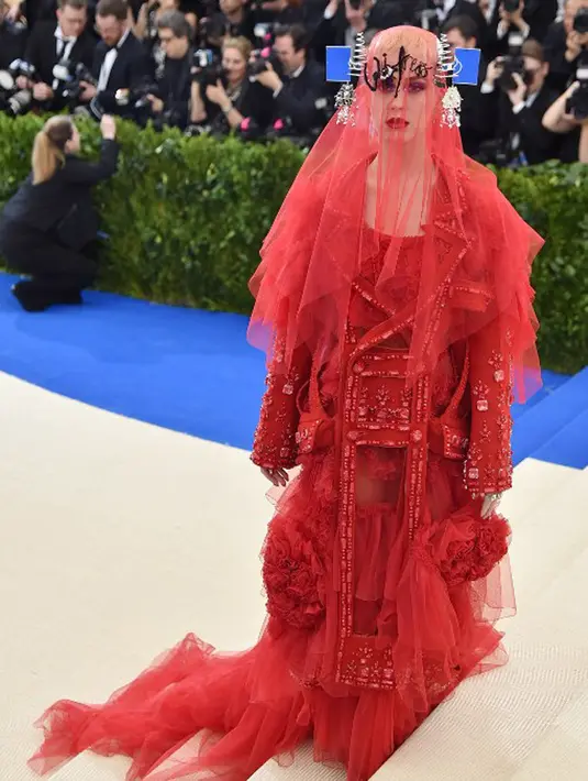Tampilan Katy Perry di Met Gala 2017 memang begitu unik. Pakaian yang serba merah, ditambah dengan tutup kepala yang menjuntai menutupi wajahnya ini membuat Katy begitu unik. (AFP/Bintang.com)