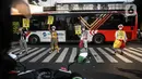 Angggota Komunitas Aku Badut Indonesia (ABI) melakukan aksi kampanye penggunaan di kawasan Cilandak, Jakarta Selatan, Senin (12/7/2021). Selain itu, mereka juga membagi-bagikan masker secara gratis bagi para pengendara motor yang melintas. (Liputan6.com/Johan Tallo)