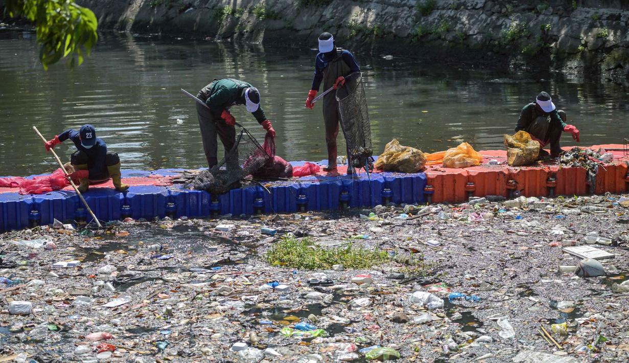 Selain mengangkat sampah, relawan juga memilah jenis limbah yang terbawa arus sungai. Tampak dalam foto, aktivis dari Ecoton (Ecological Observation and Wetlands Conservation) bersama pekerja dari Dinas Lingkungan Hidup Pemerintah Kota Surabaya, Jawa Timur, membersihkan sampah dari Sungai Kali Tebu, pada Senin 11 Mei 2026. (JUNI KRISWANTO/AFP)