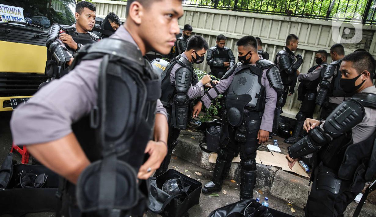 Personel Brimob bersiap mengenakan perlengkapan pelindung diri di Kawasan Bundaran HI, Jakarta, Selasa (13/10/2020). Sebanyak kurang lebih 12 ribu personel gabungan TNI, Polri dan Pemprov DKI Jakarta diterjunkan mengawal aksi tolak Undang-Undang Cipta Kerja Omnibus Law. (Liputan6.com/Faizal Fanani)