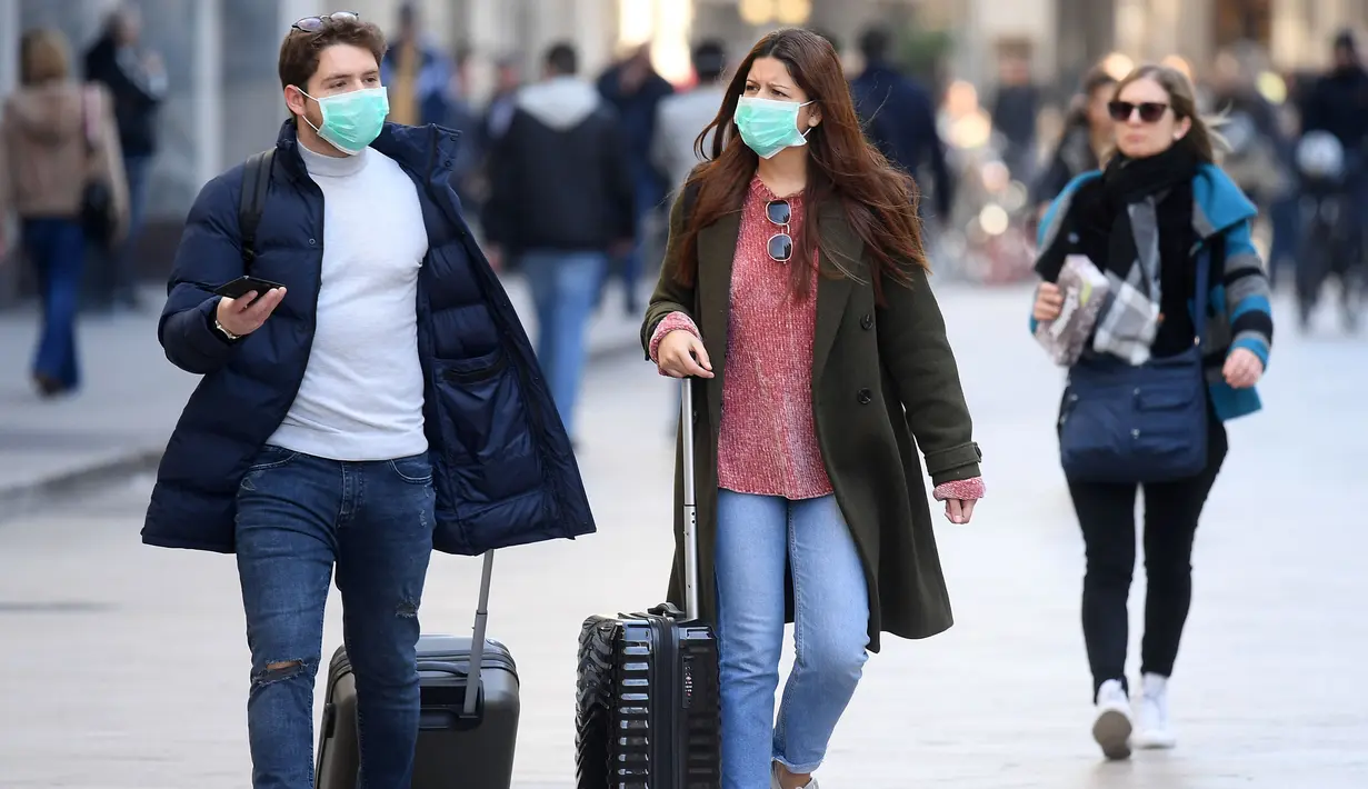 Orang-orang memakai masker berjalan di Milan, Italia (24/2/2020). Kepala Departemen Perlindungan Sipil sekaligus Komisaris Luar Biasa untuk Darurat Coronavirus, Angelo Borrelli mengatakan enam orang meninggal dan 222 lainnya teruji positif infeksi COVID-19 di Italia. (Xinhua/Daniele Mascolo)