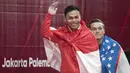 Lifter Indonesia, Eko Yuli Irawan, menyapa suporter usai berlaga pada Asian Games di JIExpo, Jakarta, Selasa, (21/8/2018). Eko Yuli berhasil menyumbang medali emas angkat besi putra kelas 62kg. (Bola.com/Peksi Cahyo)