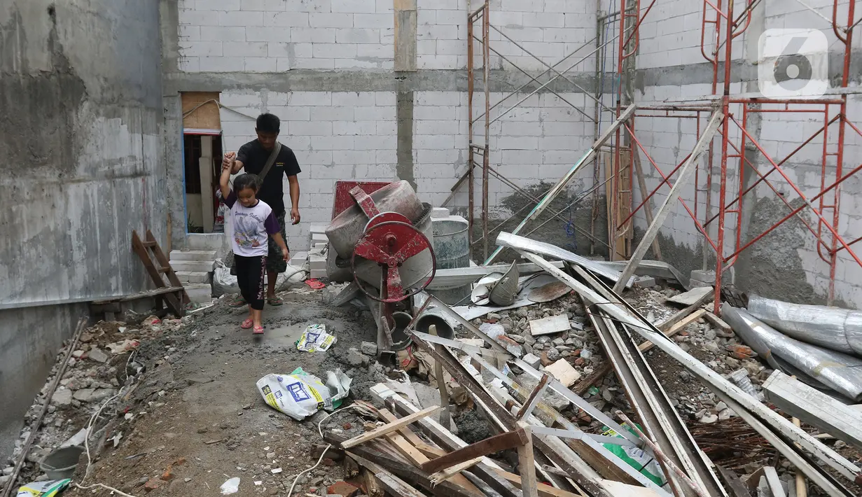 Salah satu kerabat pemilik rumah saat keluar dari rumah di kawasan Mangga Dua Dalam, Jakarta, Kamis (12/12/2019). Mereka terpaksa harus melewati puing-puing yang berserakan di lokasi pembangunan gudang. (Liputan6.com/Herman Zakharia)