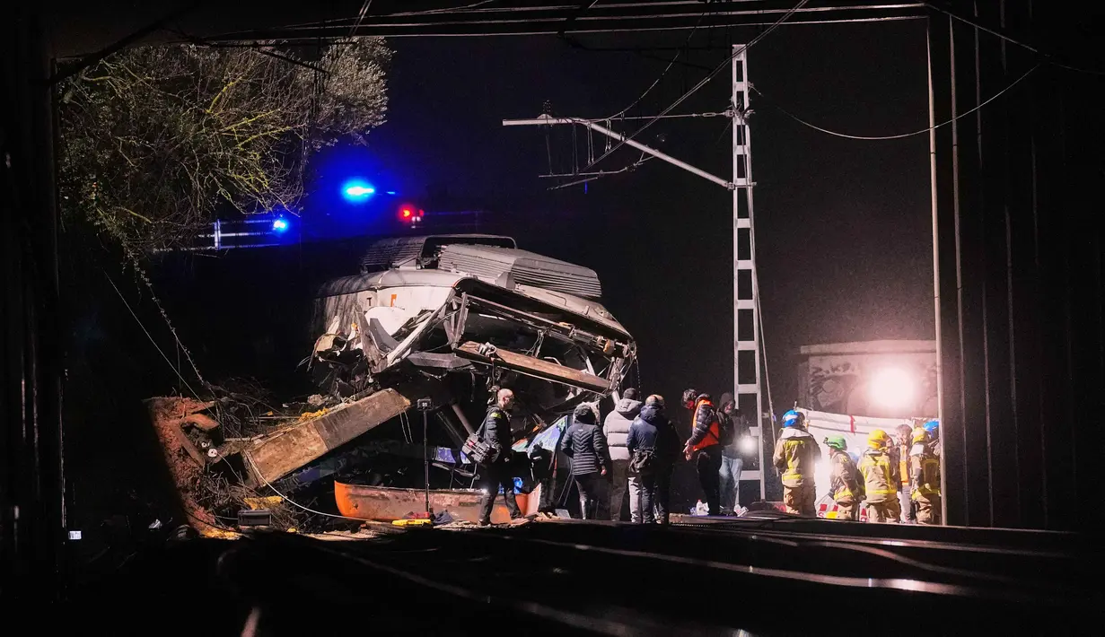 Pejabat setempat melaporkan kereta Rodalies tersebut menabrak tembok penahan yang runtuh ke atas rel di antara wilayah Gelida dan Sant Sadurni. Tampak dalam foto, tim penyelamat merespons setelah sebuah kereta komuter tergelincir akibat menabrak tembok penahan yang runtuh ke rel di Gelida, dekat Barcelona, Spanyol, pada Selasa 20 Januari 2026. (AP Photo/Joan Mateu Parra)