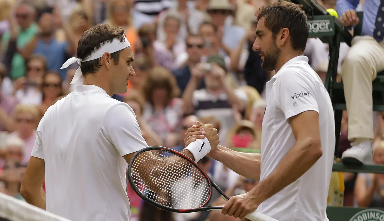 Petenis Swiss, Roger Federer, berjabat tangan dengan petenis Kroasia, Marin Cilic usai laga final Wimbledon 2017 di London, Minggu (16/7/2017). Federer menang 6-3, 6-1, 6-4 atas Cilic. (AP/Alastair Grant)