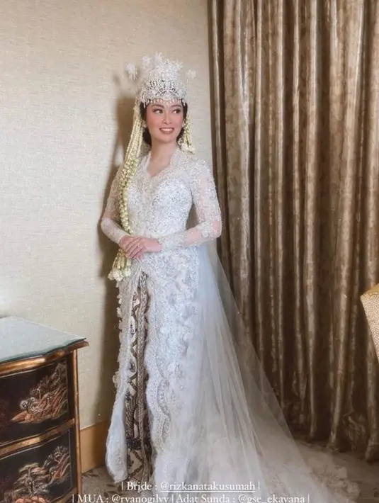 Rizka tampil anggun mengenakan kebaya warna putih bertabur payet rancangan Myrna Myura.   [Foto: IG/myrnamyura/rizkanatakusumah].