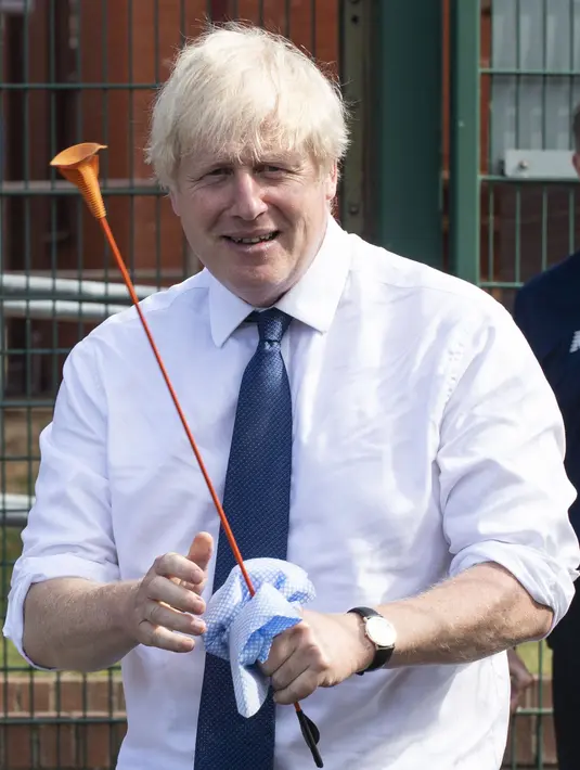 PM Inggris Boris Johnson bermain panahan saat mengunjungi Premier Education Summer Camp di Sacred Heart of Mary Girl's School, Upminster, Inggris, Senin (10/8/2020). Kunjungan Boris untuk melihat persiapan jelang pembukaan kembali sekolah pada September mendatang. (Lucy Young/Pool via AP)