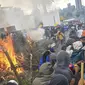 Demonstran membakar pohon di luar gedung parlemen di Quito (8/10/2019). Unjuk rasa ini telah berlangsung selama beberapa hari dan diikuti berbagai elemen termasuk masyarakat adat. (AFP Photo/Martin Bernetti)