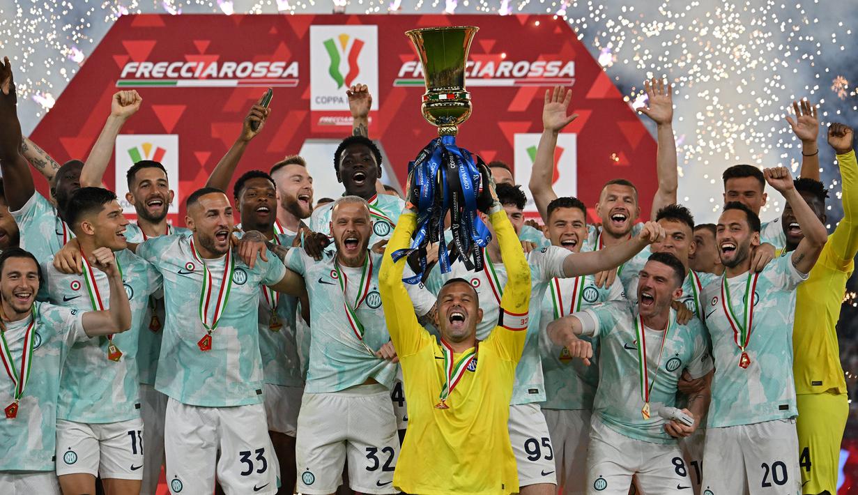 Kiper sekaligus Kapten Inter Milan, Samir Handanovic (tengah) mengangkat trofi saat timnya merayakan kemenangan atas Fiorentina setelah laga final Coppa Italia di Stadio Olimpico, Roma, 24 Mei 2023. (AFP/Alberto Pizzoli)