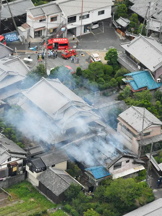 Asap mengepul dari sebuah rumah usai gempa bumi menghantam Takatsuki, Osaka, Jepang, Senin (18/6). Gempa bumi dilaporkan terjadi sebelum jam 08.00 pagi saat penduduk setempat sedang menuju tempat kerja. (Yohei Nishimura/Kyodo News via AP)