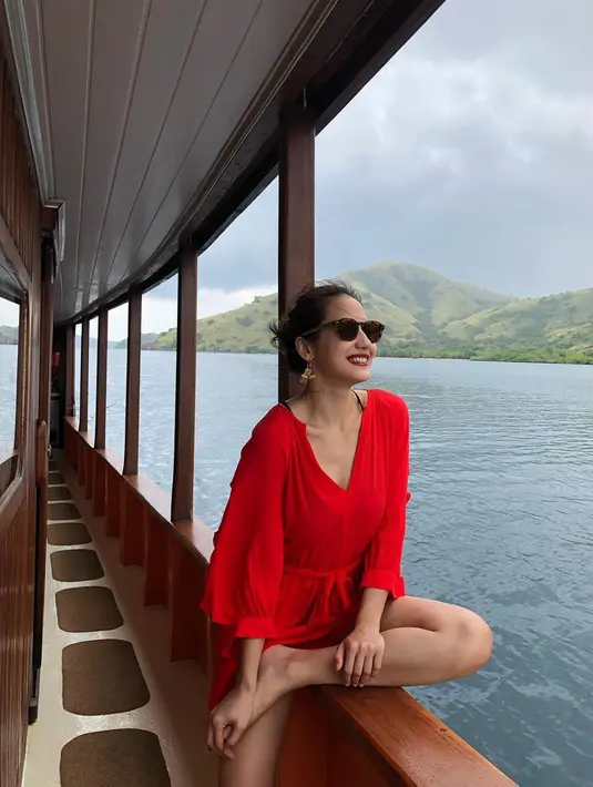 Saat liburan, Pevita tetap tampil modis dengan jumpsuit merah serta aksesoris kacamata hitam. Penampilannya ini banyak dipuji netizen. (Liputan6.com/IG/@pevpearce)