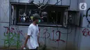 Seorang anak muda melintasi Pos Polisi yang dirusak massa di kawasan Gondangdia, Jakarta, Kamis (8/10/2020). Aksi anarkis massa dilakukan saat berunjuk rasa menentang disahkan Omnibus Law UU Cipta Kerja. (Liputan6.com/Helmi Fithriansyah)