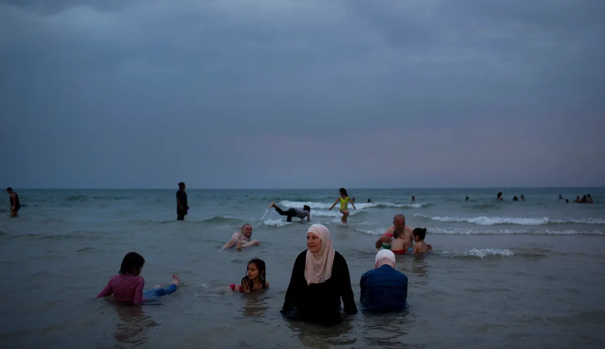 Keceriaan warga Palestina saat menghabiskan libur Idul Fitri di pantai Tel Aviv, Israel, Sabtu (16/6). (AP Photo/Oded Balilty)