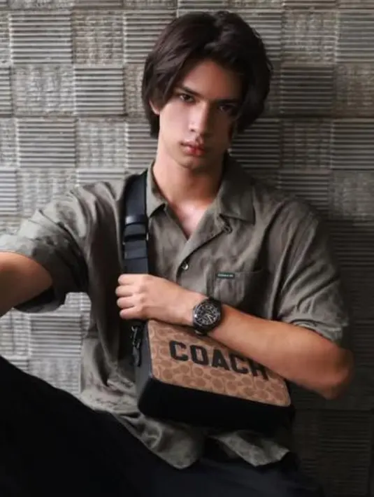 Charter Crossbody 24 In Signature Canvas With Coach Graphic Untuk perjalanan dekat maupun jauh, tas Charter Crossbody Bag membuat penampilan menjadi effortlessly stylish, terutama pada penampilan aktor Tanah Air Arya Mohan. Tas berstruktur ini mengusung desain fungsional dan estetik, serta terbuat dari bahan kulit dan kain kanvas Signature yang menampilkan logo grafik Coach yang khas. Untuk memudahkan penyimpanan barang, tas ini memiliki dua kantong dengan resleting. Tali strap dengan bahan webbing memudahkan penyesuaian penggunanya untuk berbagai macam acara. [Coach]