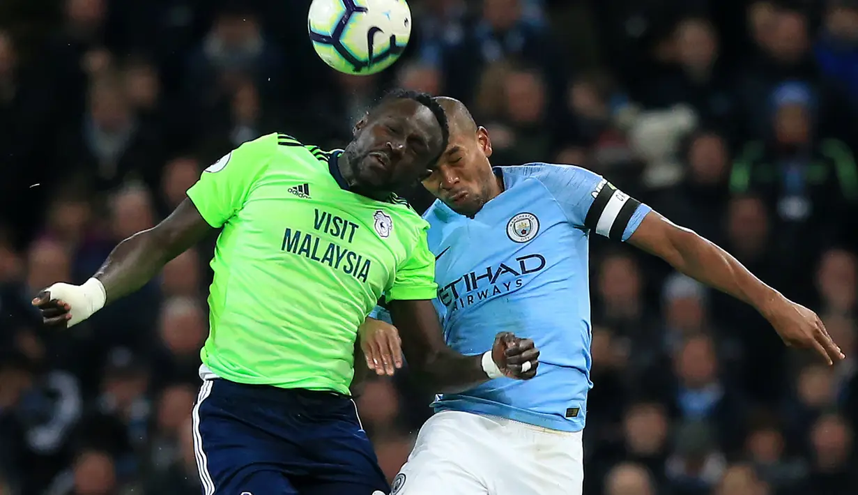 Duel udara antara Niesse dan Fernandinho pada laga lanjutan Premier League yang berlangsung di Stadion Etihad, Manchester, Kamis (4/4). Manchester City menang 2-0 atas Cardiff City. (AFP/Oli Scarff)