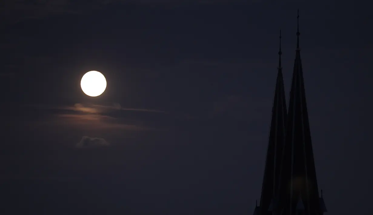 Fenomena Supermoon terlihat terbit di atas menara gereja Familienkirche di Wina, Selasa (9/9/14). (REUTERS/Heinz-Peter Bader)