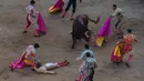 Sejumlah matador berusaha menyelamatkan rekannya yang tergeletak di tanah setelah ditanduk banteng di Festival San Fermin Pamplona pada tanggal 8 Juli 2016.( AFP PHOTO / MIGUEL RIOPA)