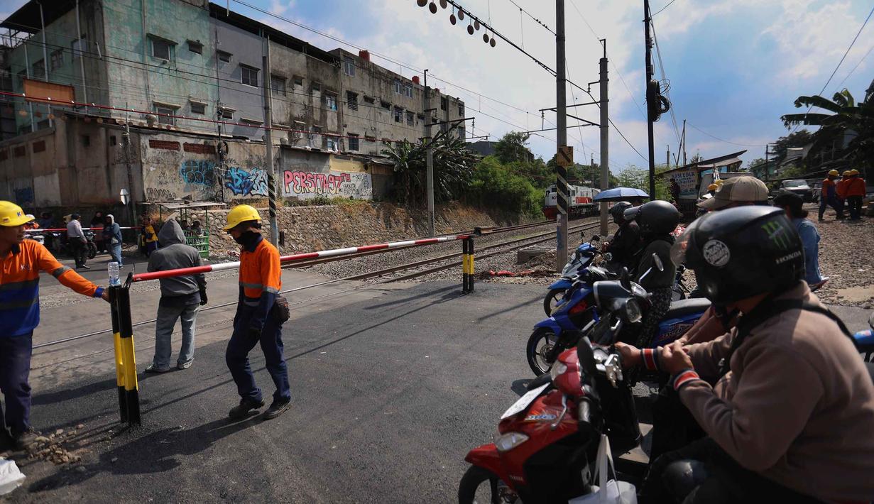 Sebagai informasi, sebelumnya perlintasan sebidang ini tidak resmi atau liar serta tidak memiliki palang pintu. Tampak dalam foto, aktivitas pekerja dari PT Kereta Api Indonesia (KAI) Daop 1 Jakarta saat proses pemasangan palang pintu di perlintasan sebidang Jalan Ampera, dekat Stasiun Bekasi Timur, Bekasi, Jawa Barat. (Kapanlagi.com/Budy Santoso)
