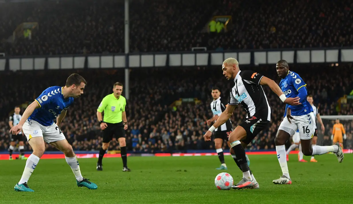 Striker Newcastle United Joelinton (kedua kanan) berebut bola dengan bek Everton Seamus Coleman (kiri) pada lanjutan Liga Inggris di Stadion Goodison Park, Liverpool, Jumat (18/3/2022) dini hari WIB. Bertindak sebagai tuan rumah, Everton menang tipis 1-0.  (Anthony Devlin / AFP)