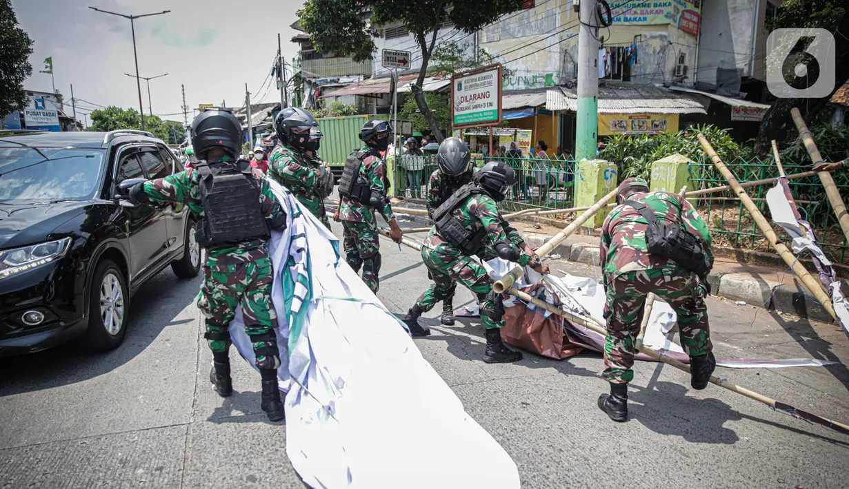 Anggota TNI mencopot paksa baliho Rizieq Shihab yang terpasang di sekitar kawasan Petamburan, Jakarta, Jumat (20/11/2020). Pencopotan dilakukan karena menyalahi aturan yang telah ditetapkan. (Liputan6.com/Faizal Fanani)
